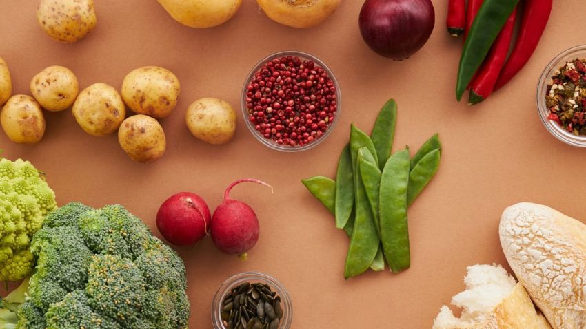 Top view of fresh ingredients including vegetables and bread, ideal for healthy cooking concepts.